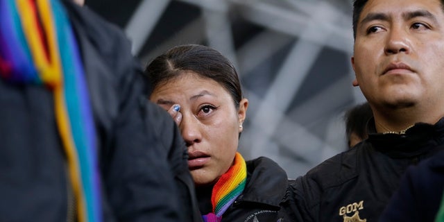 A policewoman, who was detained by anti-government protesters, cries while standing on a stage at the Casa de Cultura in Quito. (AP Photo/Fernando Vergara)