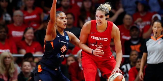 Washington Mystics forward Elena Delle Donne, right, drives against Connecticut Sun forward Alyssa Thomas during the first half of Game 5 of basketball's WNBA Finals, Thursday, Oct. 10, 2019, in Washington. (Associated Press)