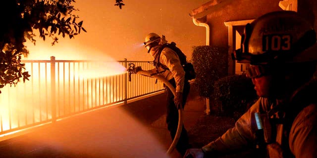 In this Thursday, Oct. 10, 2019 photo, Los Angeles City firefighters battle the Saddleridge fire near homes in Sylmar, Calif. (Associated Press)