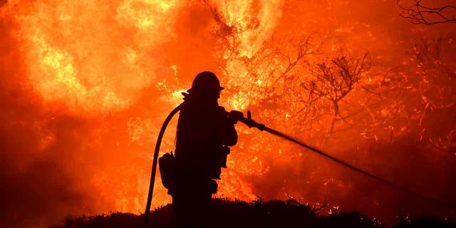 The Saddleridge fire flares up near a firefighter in Sylmar, Calif., Thursday, Oct. 10, 2019. (Associated Press)