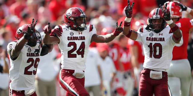 South Carolina defensive backs Israel Mukuamu (24) celebrates with J.T. Ibe (29) and R.J. Roderick (10) after intercepting a pass in the second half of an NCAA college football game against Georgia, Saturday, Oct. 12, 2019, in Athens, Ga. South Carolina won 20-17 in double overtime. (AP Photo/John Bazemore)
