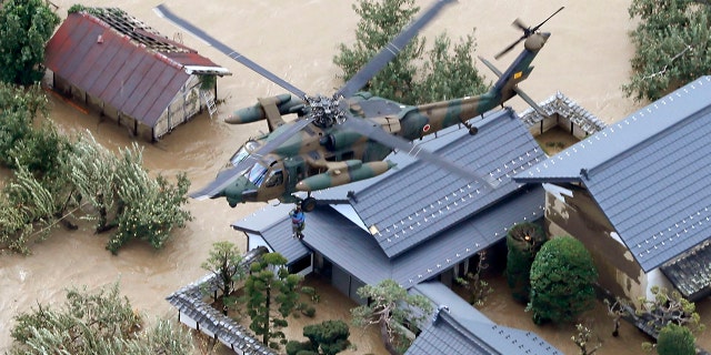 A resident is rescued by a Japan Self-Defense Force helicopter as the house is submerged in muddy waters after an embankment of the Chikuma River broke because of Typhoon Hagibis, in Nagano, central Japan, Sunday, Oct. 13, 2019. Rescue efforts for people stranded in flooded areas are in full force after a powerful typhoon dashed heavy rainfall and winds through a widespread area of Japan, including Tokyo.(Yohei Kanasashi/Kyodo News via AP)