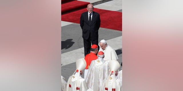 Vatican head of security Domenico Giani, top, looks at Pope Francis at the end of a canonization Mass in St. Peter's Square at the Vatican on Sunday. (AP Photo/Alessandra Tarantino)