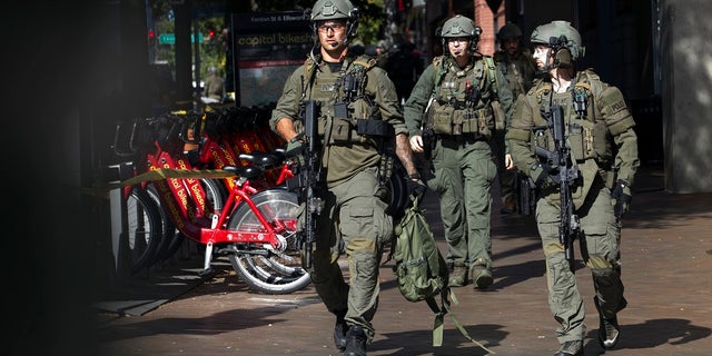 Montgomery County police officers in tactical gear exit the garage where Bomba was found Monday. (AP Photo/Jose Luis Magana)