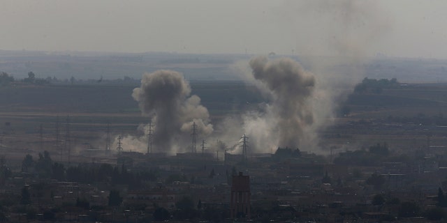 In this photo taken from the Turkish side of the border between Turkey and Syria, in Ceylanpinar, Sanliurfa province, southeastern Turkey, smoke billows from targets in Ras al-Ayn, Syria, caused by bombardment by Turkish forces, Tuesday, Oct. 15, 2019. 