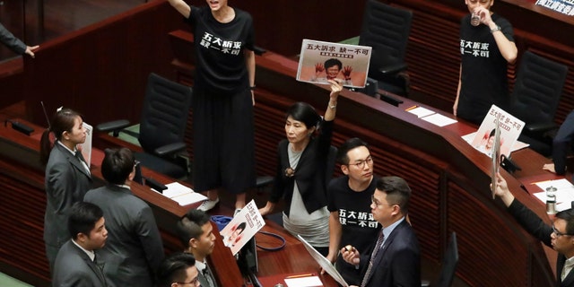Pro-democracy lawmakers protest as Hong Kong Chief Executive Carrie Lam delivers a speech at chamber of the Legislative Council in Hong Kong Wednesday, Oct. 16, 2019. Chanting pro-democracy lawmakers have interrupted the start of a speech that Lam was giving laying out her policies.