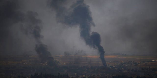 In this photo taken from the Turkish side of the border between Turkey and Syria, in Ceylanpinar, Sanliurfa province, southeastern Turkey, smoke billows from targets in Ras al-Ayn, Syria, during bombardment by Turkish forces, Wednesday, Oct. 16, 2019. Turkey's President Recep Tayyip Erdogan called Wednesday on Syrian Kurdish fighters to leave a designated border area in northeast Syria 'as of tonight' for Turkey to stop its military offensive, defying pressure on him to call a ceasefire and halt its incursion into Syria, now into its eighth day. (AP Photo/Lefteris Pitarakis)