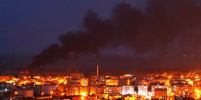 In this photo taken from the Turkish side of the border between Turkey and Syria, in Ceylanpinar, Sanliurfa province, southeastern Turkey, smoke billowed from fires in Ras al-Ayn, Syria, caused by bombardment by Turkish forces, on Wednesday. (AP Photo/Lefteris Pitarakis)
