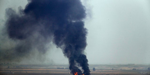 Oct. 17: In this photo taken from the Turkish side of the border between Turkey and Syria, in Ceylanpinar, Sanliurfa province, southeastern Turkey, flames and smoke billow from a fire on a target in Ras al-Ayn, Syria, caused by shelling by Turkish forces. (Associated Press)