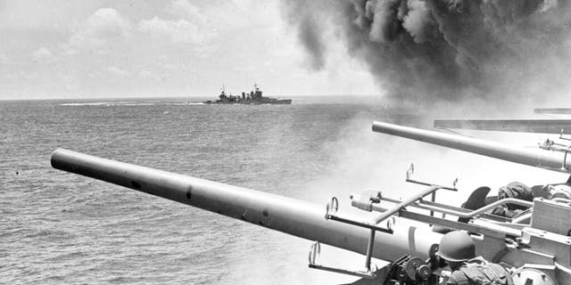 In this June 4, 1942 file photo provided by the U.S. Navy, the USS Astoria (CA-34) steamed by USS Yorktown (CV-5), shortly after the carrier had been hit by three Japanese bombs in the Battle of Midway. 