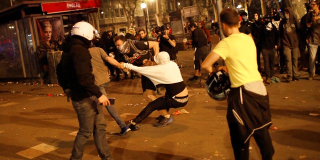 Pro-independence supporters scuffle with rioters trying to set up barricades on the street near a pro-independence demonstration in Barcelona, Spain, Saturday, Oct. 19, 2019. Radical separatists have clashed with police each night in Barcelona and other Catalan cities following huge peaceful protests of people angered by Monday's Supreme Court verdict that sentenced nine separatist leaders to prison. (AP Photo/Emilio Morenatti)