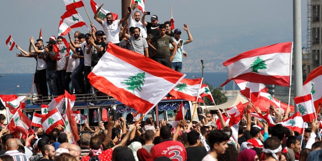Anti-government protesters chant slogans and wave their national flags at Martyr's Square, in downtown Beirut, Lebanon, Sunday, Oct. 20, 2019. Lebanon is bracing for what many expect to be the largest protests in the fourth day of anti-government demonstrations. Thousands of people of all ages were gathering in Beirut's central square Sunday waving Lebanese flags and chanting the, "people want to bring down the regime." (AP Photo/Hussein Malla)