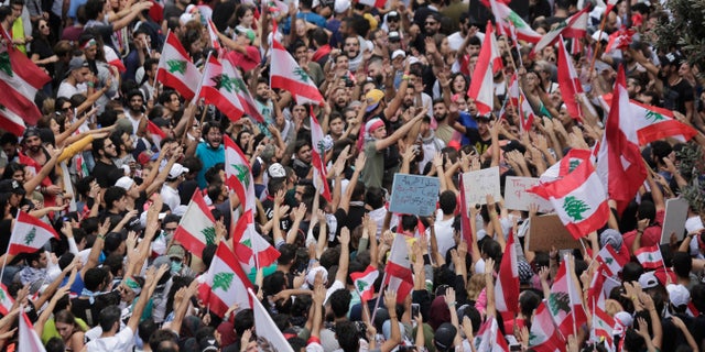 Anti-government protesters shout slogans in Beirut, Lebanon, Sunday, Oct. 20, 2019. Thousands of people are gathering in downtown Beirut as Lebanon is expected to witness the largest protests on the fourth day of anti-government demonstrations. (AP Photo/Hassan Ammar)