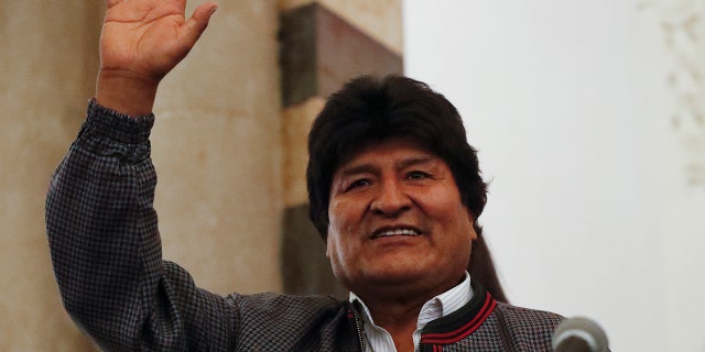 Bolivian President Evo Morales waves to supporters at the presidential palace in La Paz, Bolivia, after a first-round presidential election, Sunday, Oct. 20.