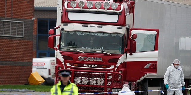 Police forensic officers attend the scene after a truck was found to contain a large number of dead bodies, in Thurrock, South England, Wednesday Oct. 23, 2019. Police in southeastern England said that 39 people were found dead Wednesday inside a truck container believed to have come from Bulgaria. (AP Photo/Alastair Grant)