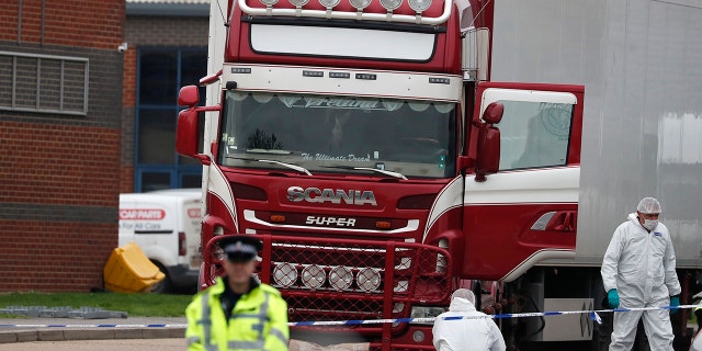 Police forensic officers attend the scene after a truck was found to contain a large number of dead bodies, in Thurrock, South England, Wednesday Oct. 23, 2019. (AP Photo/Alastair Grant)