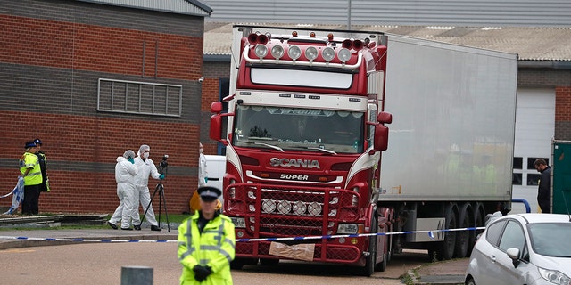 Police forensic officers attend the scene after a truck was found to contain a large number of dead bodies, in Thurrock, South England, Wednesday Oct. 23, 2019. Police in southeastern England said that 39 people were found dead Wednesday inside a truck container believed to have come from Bulgaria.
