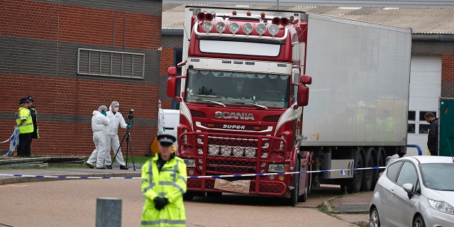 Police forensic officers attend the scene after a truck was found to contain a large number of dead bodies, in Thurrock, South England, Wednesday Oct. 23, 2019. Police in southeastern England said that 39 people were found dead Wednesday inside a truck container believed to have come from Bulgaria.