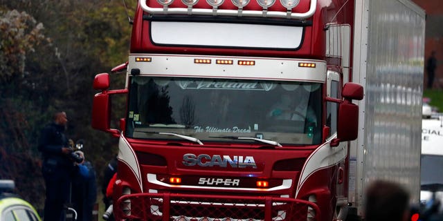 Police escort the truck, that was found to contain a large number of dead bodies, as they move it from an industrial estate in Thurrock, south England, Wednesday.