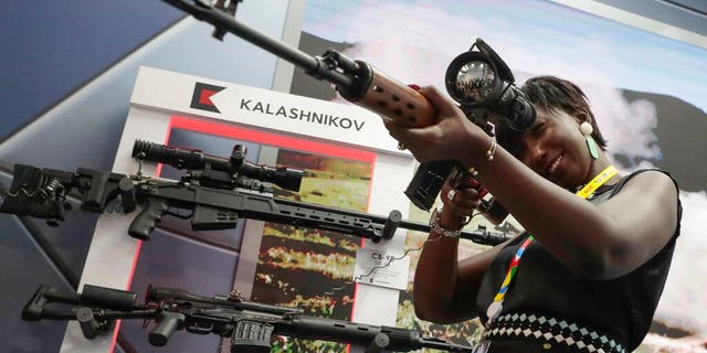 A visitor handles a sniper's rifle at an exhibition of Kalashnikov company weaponry on the sidelines of African countries at the Russia-Africa summit in the Black Sea resort of Sochi, Russia, Thursday, Oct. 24, 2019.