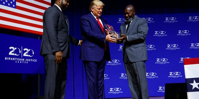 President Donald Trump is awarded the Bipartisan Justice Award by Matthew Charles, right, one of the first prisoners released by the First Step Act, during the 