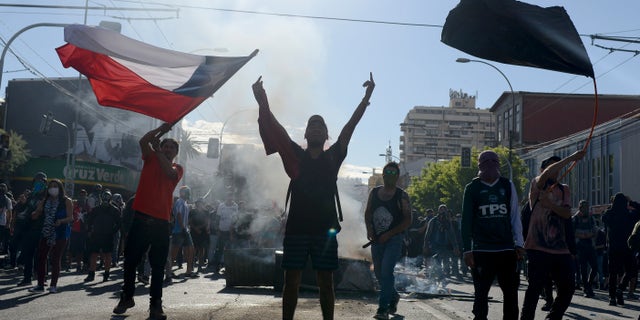 Anti-government protesters face off with police in Valparaiso, Chile, Friday, Oct. 25, 2019. A new round of clashes broke out Friday as demonstrators returned to the streets, dissatisfied with economic concessions announced by the government in a bid to curb a week of deadly violence.(AP Photo/Matias Delacroix)