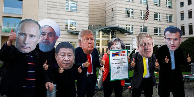 Protestors with masks of world leaders protest in front of the United States embassy, demanding a new nuclear agreement with Iran to avoid a possible armed conflict at the mideast region, in Berlin, Saturday, Oct. 26, 2019. 