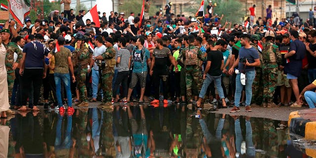 Anti-government protesters gather near Basra provincial council building during a demonstration in Basra, Iraq, Monday, Oct. 28, 2019.