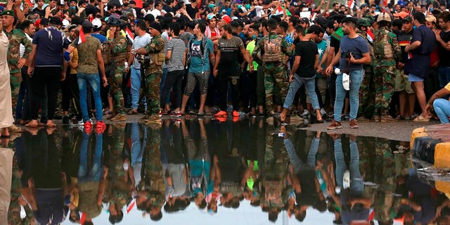 Anti-government protesters gather near Basra provincial council building during a demonstration in Basra, Iraq, Monday, Oct. 28, 2019.