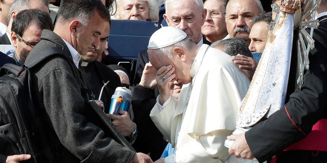 Pope Francis appears to wipe away tears as he stands in front of a plaque honoring Argentina's war dead in Argentina. (AP Photo/Andrew Medichini)