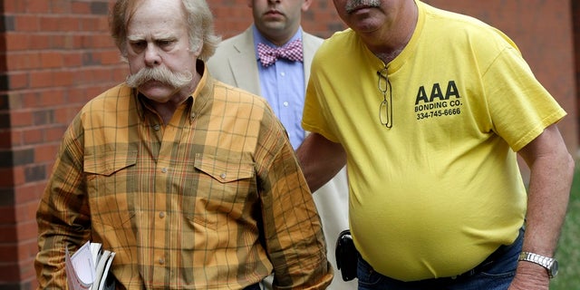 Harvey Updyke, left, leaves the Lee County Justice Center in Opelika, Ala., with his bail bondsman and his attorney in this 2013 photo. (AP Photo/Dave Martin, File)