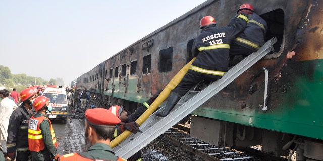 Rescue workers look for survivors following a train damaged by a fire in Liaquatpur, Pakistan, Thursday, Oct. 31, 2019. A massive fire engulfed three carriages of the train traveling in the country's eastern Punjab province