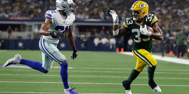 Green Bay Packers running back Aaron Jones (33) scores a touchdown against Dallas Cowboys cornerback Byron Jones (31) in the third quarter at AT&T Stadium. (Tim Heitman-USA TODAY Sports)