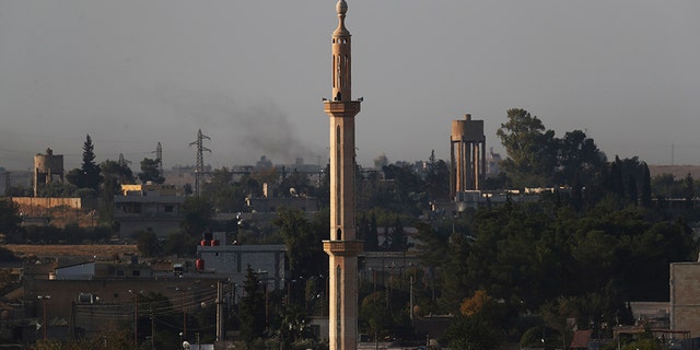 In this photo taken from the Turkish side of the border between Turkey and Syria, in Akcakale, Sanliurfa province, southeastern Turkey, the town of Tel Abyad can be seen inside Syria, Saturday, Oct. 12, 2019. (AP Photo/Lefteris Pitarakis)