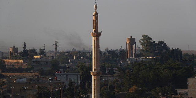 In this photo taken from the Turkish side of the border between Turkey and Syria, in Akcakale, Sanliurfa province, southeastern Turkey, the town of Tel Abyad can be seen inside Syria, Saturday, Oct. 12, 2019. (AP Photo/Lefteris Pitarakis)