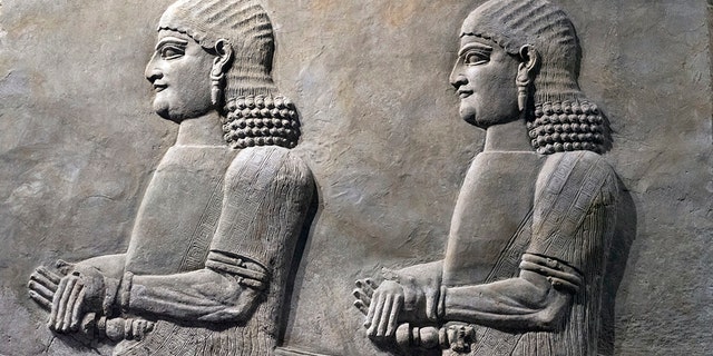 Assyrian wall relief of a genius from Mesopotamia, detail with a head. Ancient carving panel from the Middle East history. (Credit: iStock)