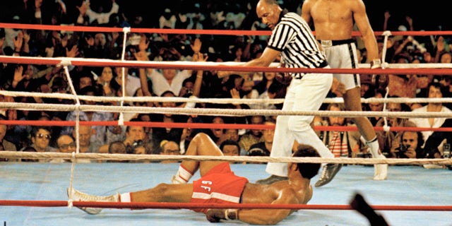 This is a Oct. 30, 1974 file photo of Muhammad Ali, right, as he stands back as referee Zack Clayton calls the count over opponent George Foreman, red shorts, in Kinshasa, Zaire.  (AP Photo, File)