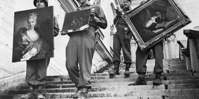 7th Army soldiers carry three valuable paintings that were looted by the Nazis down the steps of Neuschwanstein Castle at Fussen, Germany - file photo..