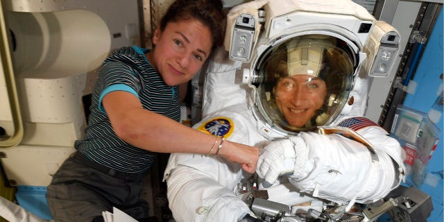 Astronauts Christina Koch, right, and, Jessica Meir pose on the International Space Station. The first all-female spacewalk is back on, six months after a flap over spacesuits led to an embarrassing cancellation. (NASA via AP)