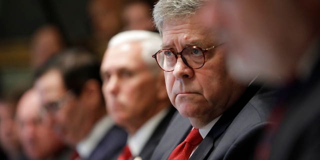 Attorney General William Barr, center, and Vice President Mike Pence, left of Barr, attend a Cabinet meeting in the Cabinet Room of the White House, Monday, Oct. 21, 2019, in Washington. (AP Photo/Pablo Martinez Monsivais)