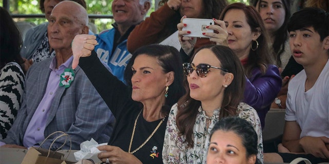 A viewer in the stands at the Columbus Day Parade gives a thumb down, while others boo and whistle as Mayor Bill de Blasio participates, Monday Oct. 14, 2019, in New York. (AP Photo/Bebeto Matthews)