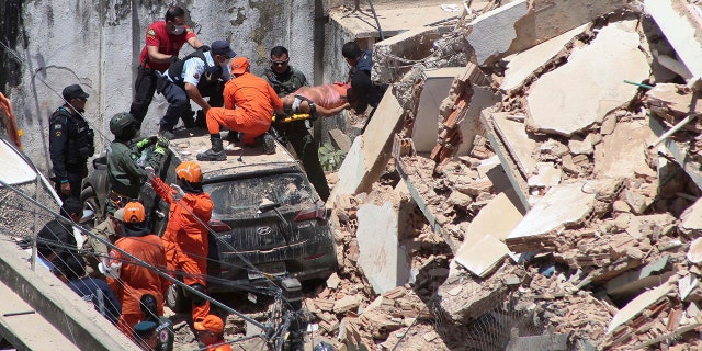 Firefighters rescue a woman from a building that collapsed in Fortaleza on Tuesday. (Kleber Goncalves/Futura Press via AP)