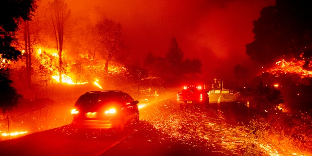 Embers fly across a roadway as the Kincade Fire burns through the Jimtown community of Sonoma County, Calif., Oct. 24, 2019.