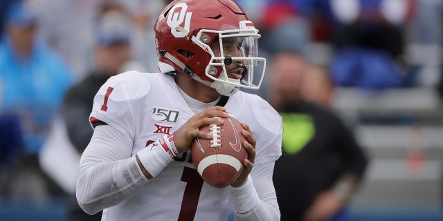 Oklahoma quarterback Jalen Hurts looks for a receiver during the second half of an NCAA college football game against Kansas, Saturday, Oct. 5, 2019, in Lawrence, Kan. (AP Photo/Charlie Riedel)