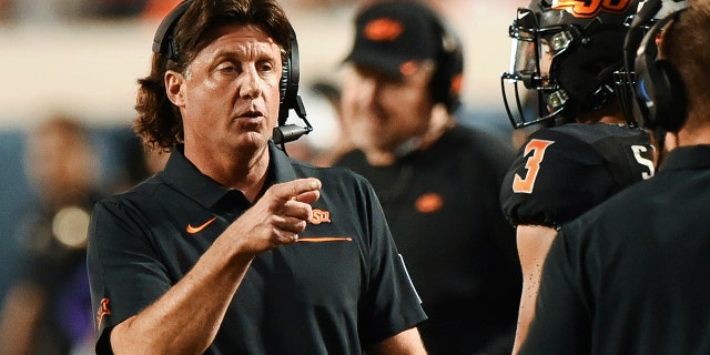 Oklahoma State head coach Mike Gundy points to his staff on the sidelines during the first half of an NCAA college football game against Kansas State, in Stillwater, Okla., Saturday, Sept. 28, 2019.