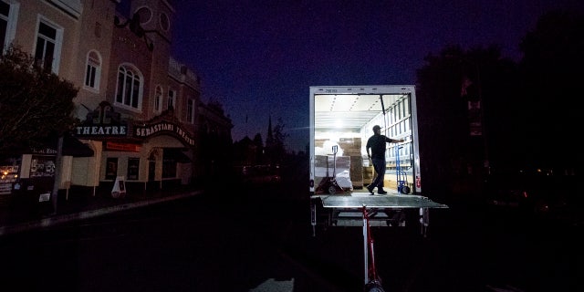 Armando Espinoza delivers paper products to a cafe in downtown Sonoma, Calif., where power is turned off, on Wednesday, Oct. 9, 2019.