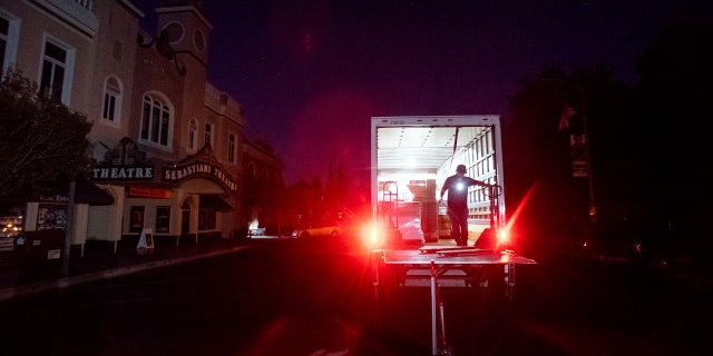 Armando Espinoza delivers paper products to a cafe in downtown Sonoma, Calif., where power is turned off, on Wednesday, Oct. 9, 2019.