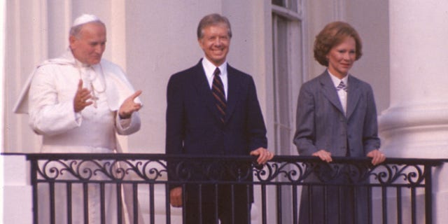 Pope John Paul II stands on the balcony of the White House with President Jimmy Carter and first lady Rosalynn Carter in Washington, D.C., on Oct. 6, 1979. (AP Photo)