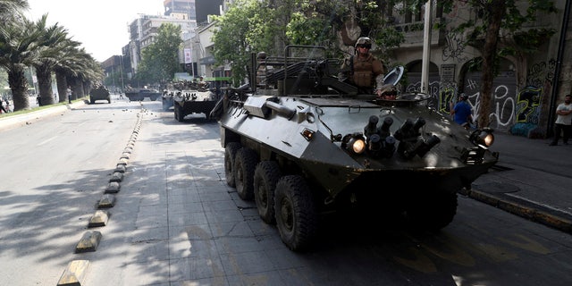 Army armored vehicles patrol the streets, after a night of riots that forced President Sebastian Pinera to announce a state of emergency, in Santiago, Chile, Saturday, Oct. 19, 2019.