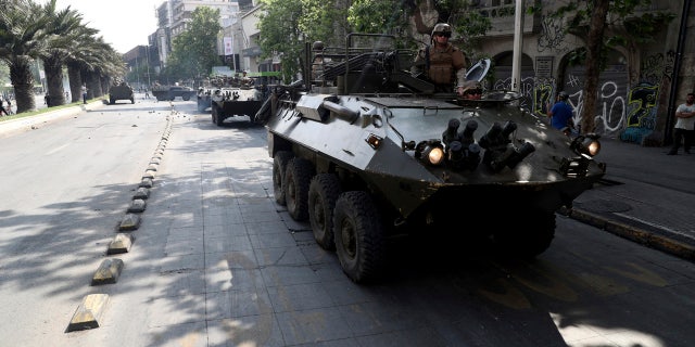Army armored vehicles patrol the streets, after a night of riots that forced President Sebastian Pinera to announce a state of emergency, in Santiago, Chile, Saturday, Oct. 19, 2019.